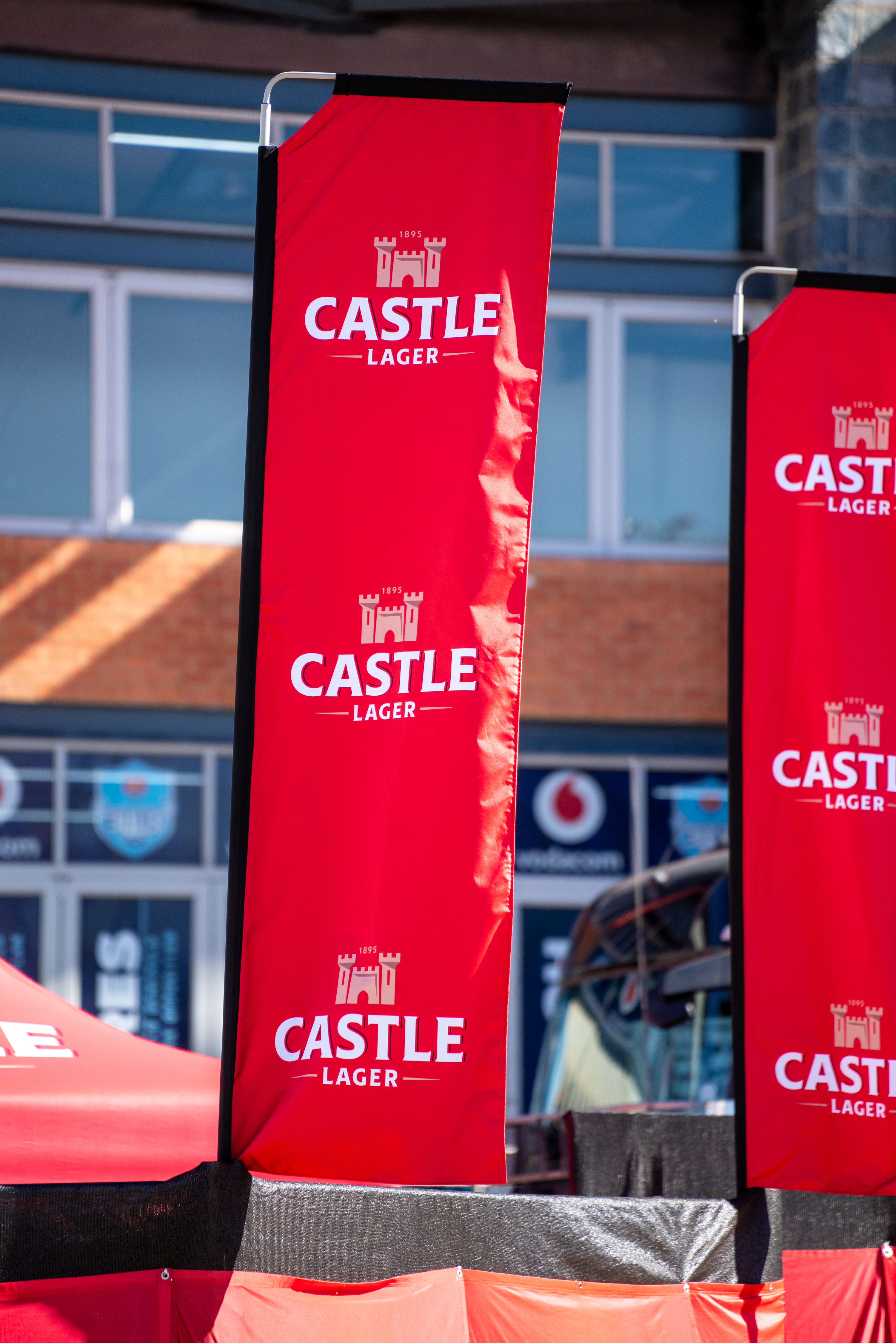 Multiple Castle Lager branded umbrellas arranged at professional South African outdoor venue